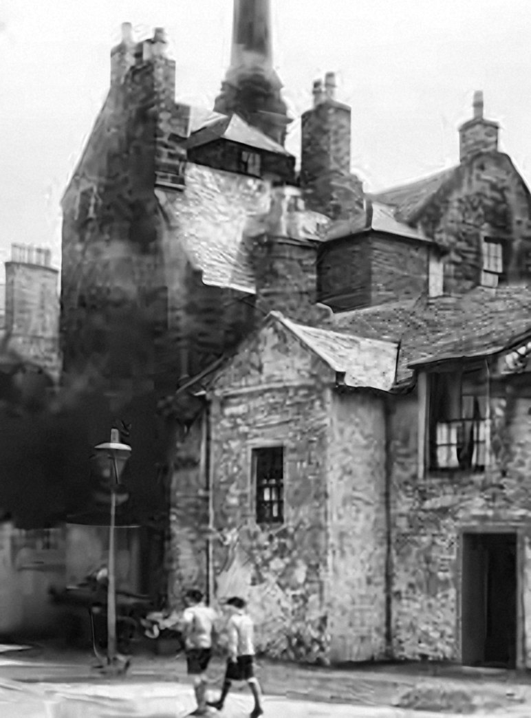 Two boys walk past Loudoun Hall and a lamp post on a cobbled lane